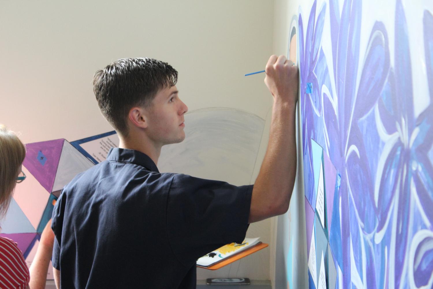 Edward Emery ’17 works on the mural at the Pine & Octavia campus. Emery assisted Artist-in-Residence Patter Hellstrom in finishing the mural that every junior has contributed to.