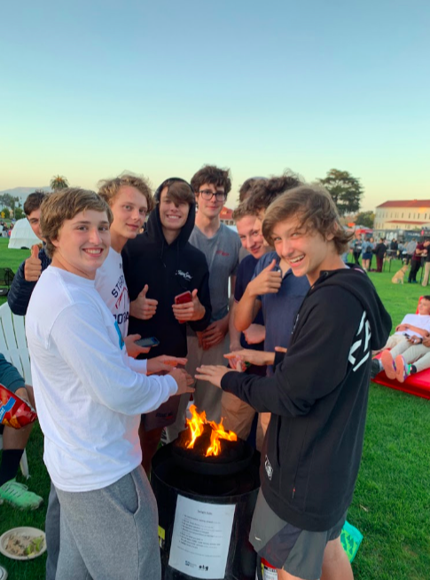 Knights football players gather around fire at Off the Grid. Players left practice at Kesar Stadium in Golden Gate Park early to attend the event.