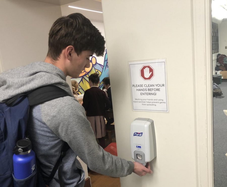 Senior Collin Ritchie uses hand sanitizer outside the Spark Studio before lunch. SAGE, the schools catering service provider, increased hand sanitizer availability in the cafeteria.