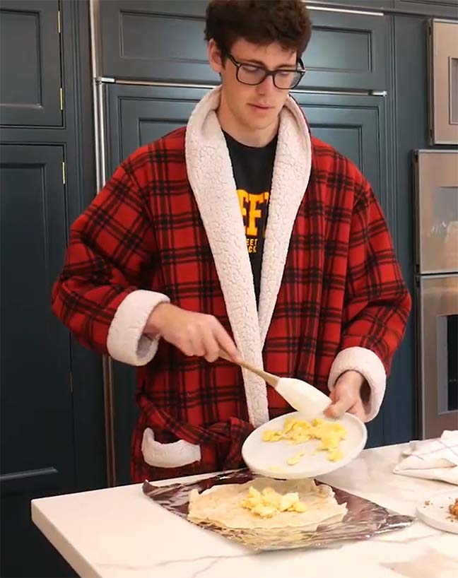 Junior Jake Falconer adds scrambled eggs to his morning burrito in the Breakfast Club’s May 8 video tutorial. The club started making weekly YouTube videos after campus closed in March.