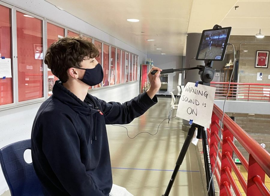 Junior Isaiah Ryan tests an iPad camera and microphone prior to a Knights basketball frosh-soph game against Urban High School in the Herbert Center on May 7, 2021. The Zoom livestream included real-time commentary.
