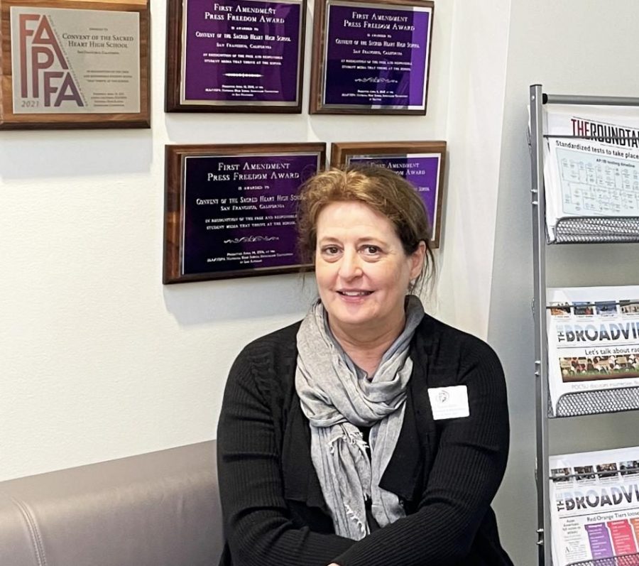 Tracy Sena, Scholastic Journalism & Media Director, sits in front of the Publications Lab with seven years of First Amendment Press Freedom Awards behind her. Sena facilitated a journalism program in which student work has been nationally recognized for its excellence.