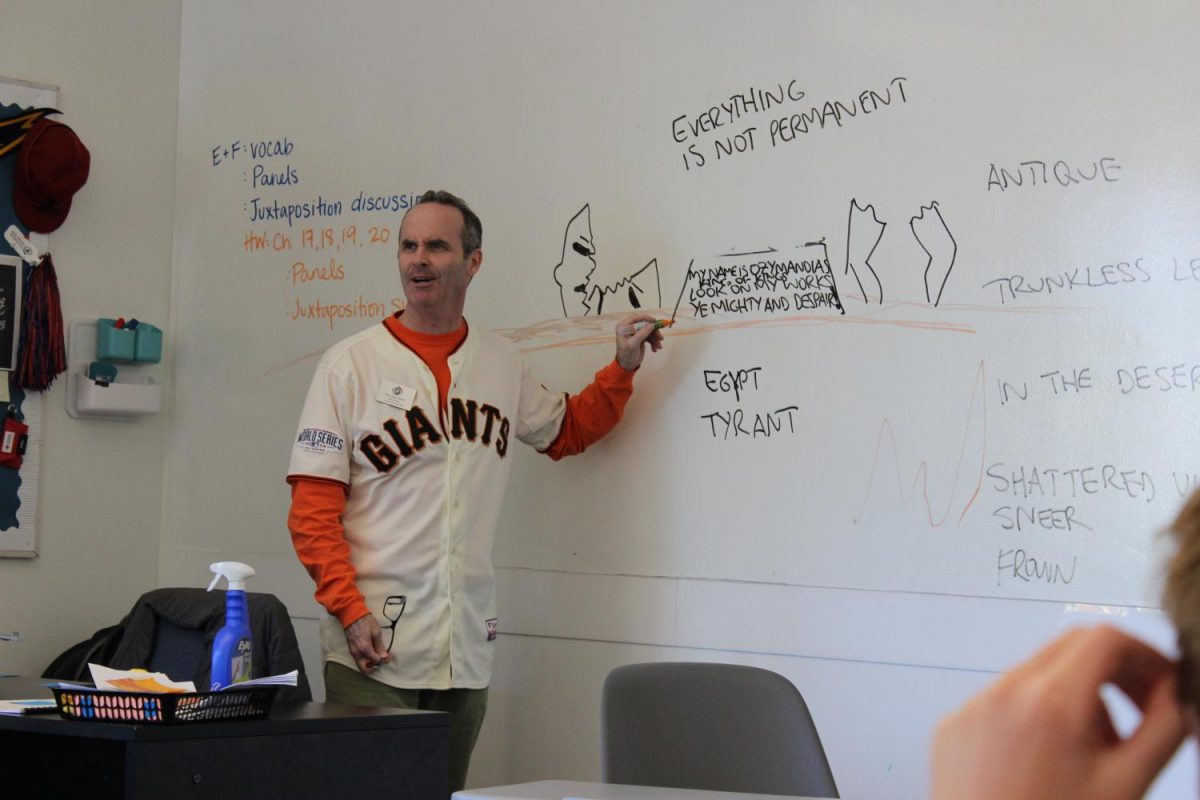 Sporting a jersey during Spirit Week, Head of School Tony Farrell teaches an English class. Administrators on the Broadway Campus are teaching classes as well.