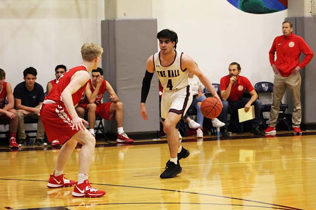 Senior Tomas Wolber gets ready to drive to the basket at Stuart Halls home game against University High School on Jan. 14. Wolber committed to Linfield Colleges team in late April.