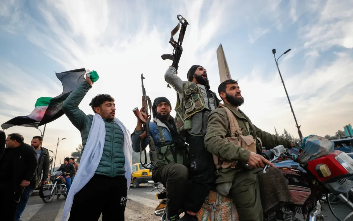 HTS fighters shoot in the air as they celebrate in Damascus. This follows the swift takeover of cities by the opposition fighters and the collapse of the Assad regime.