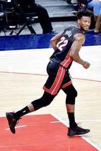 Jimmy Butler smirks as he runs back down the court. 