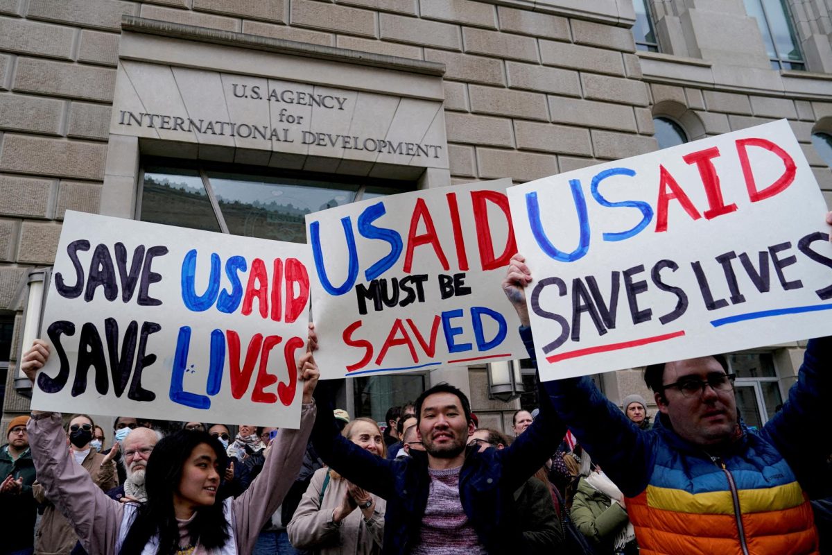 People hold placards, as the USAID building sits closed to employees after a memo was issued advising agency personnel to work remotely, in Washington, D.C., U.S., February 3, 2025.