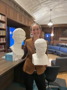 The lecturer Dr. Sarah Olsen, an associate professor of Classics at Williams College in Williamstown, Massachusetts, holds up two 3D printed Roman busts in the Williams Library.
Left: Augustus.
Right: Cicero.